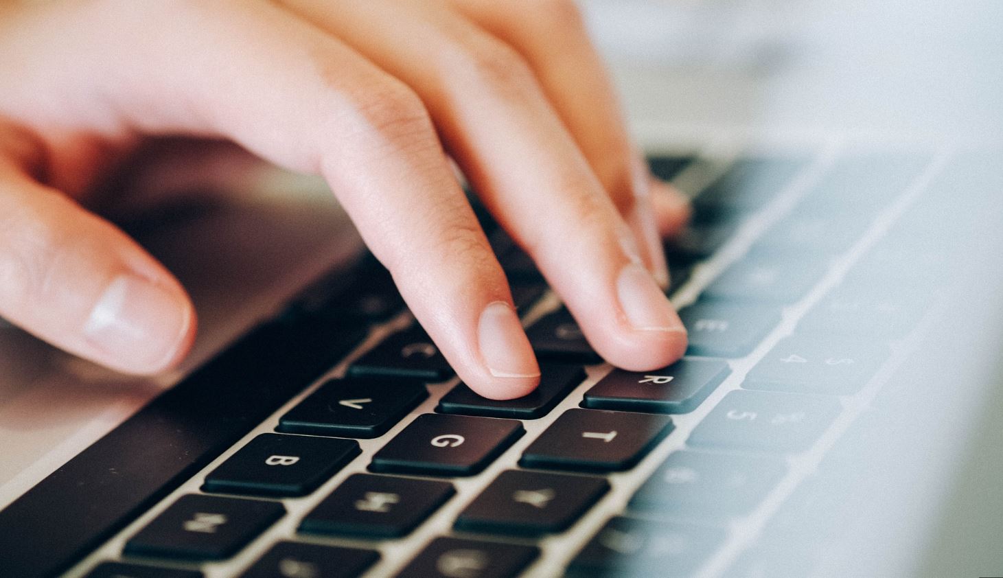 Picture of fingers touching the letter keys on a computer keyboard